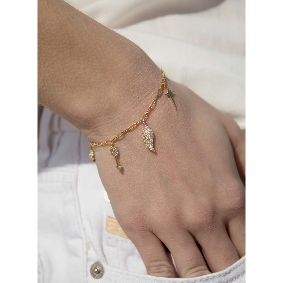 PULSERA PLATA BAÑADA EN ORO CON 5 ABALORIOS COLGANTES, ALAS, FLECHAS, ESTRELLA CON CIRCONITAS. LINEARGENT